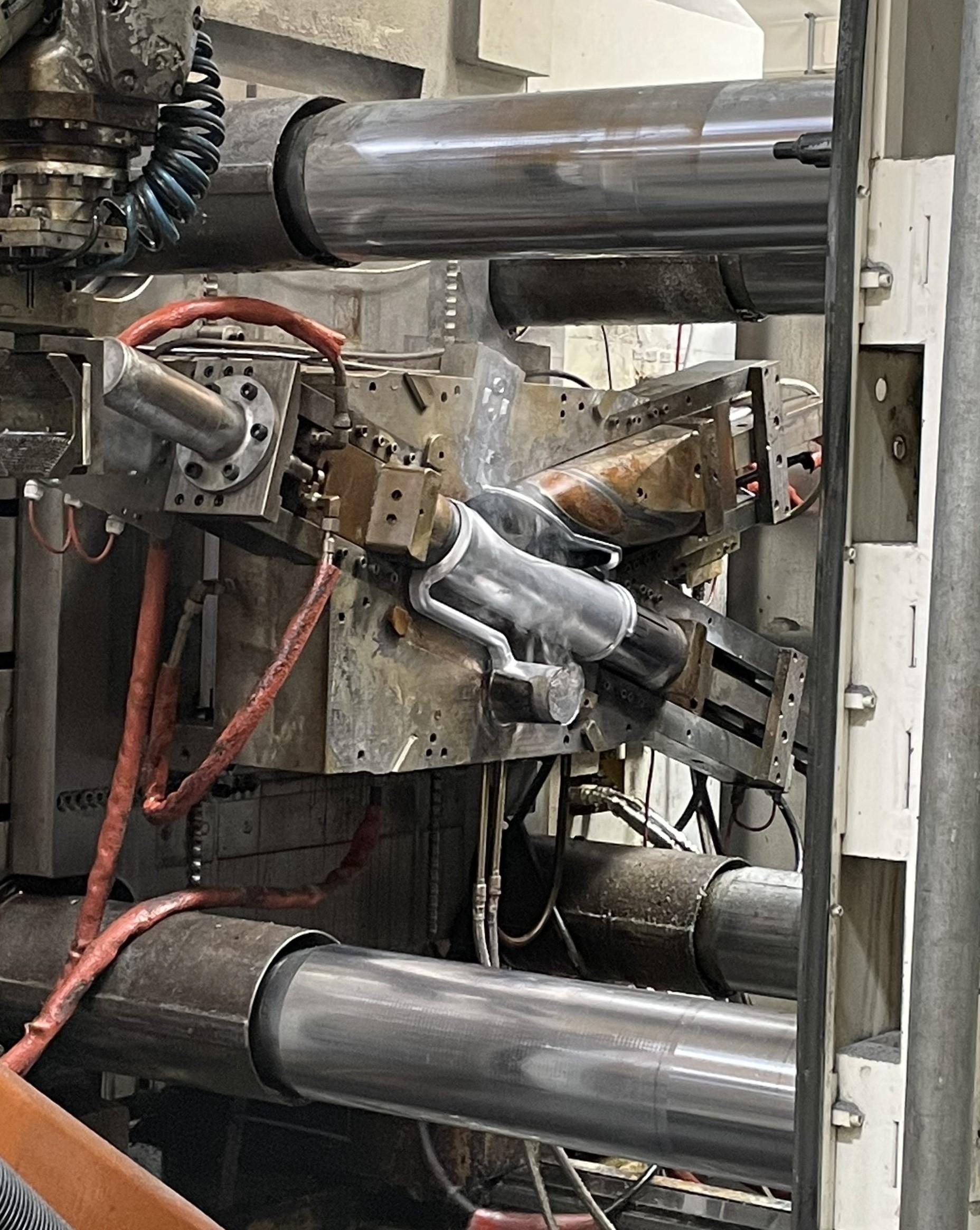 A metal part in a high pressure die-casting machine at Idé-Pro